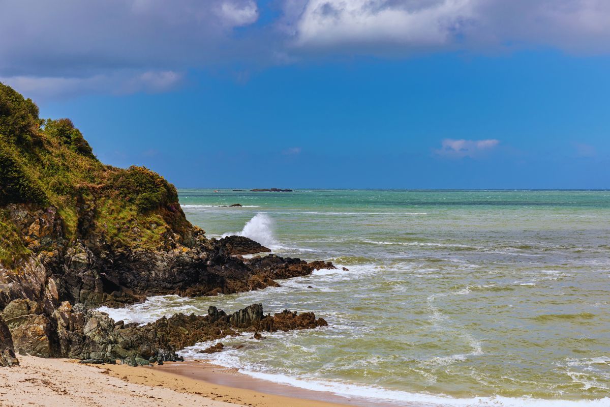 Plongez dans le secret le mieux gardé de Bretagne : la Crique de Porz Mellec, à Plestin-les-Grèves, un sanctuaire naturel entre falaises majestueuses et eaux cristallines pour le plaisir des visiteurs